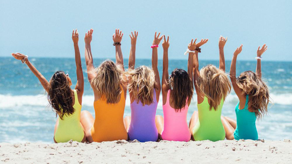 girls in colorful swimsuits out on the beach